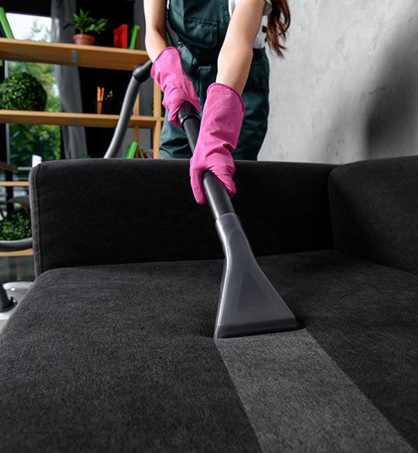 Partial View of Woman in Rubber Gloves Cleaning Furniture with Vacuum Cleaner